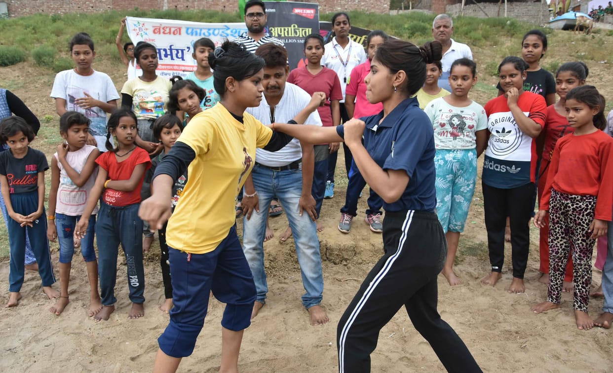Young girls learning on the banks of the river Yamuna tricks of self defense