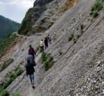 रायां में मलबे के ढेर से आवागमन करते लोग।