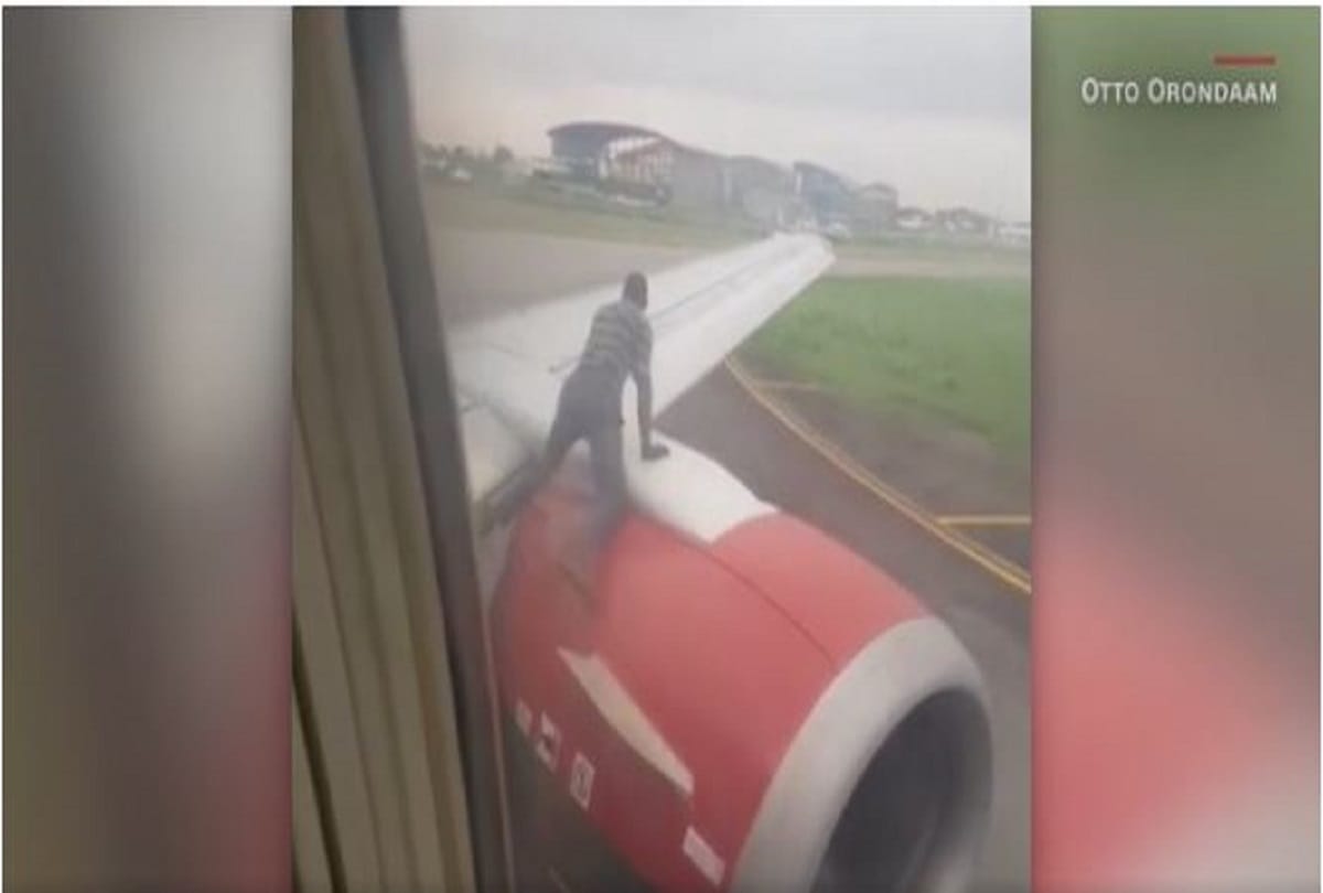 man jumping on flight wing in murtala muhammed airport