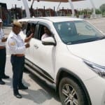 कार का चालान करते ट्रैफिक पुलिसकर्मी