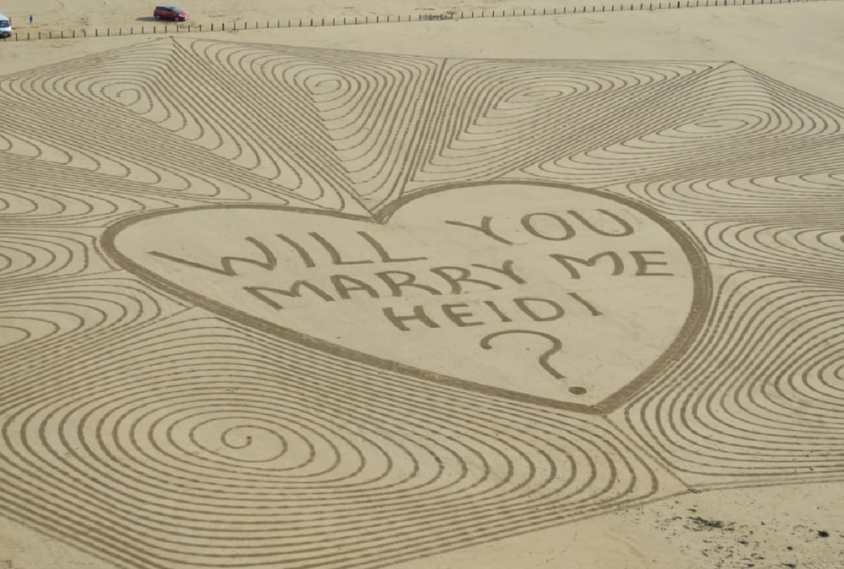 Unique marriage proposal Man propose his girlfriend at a beach by creating sand art
