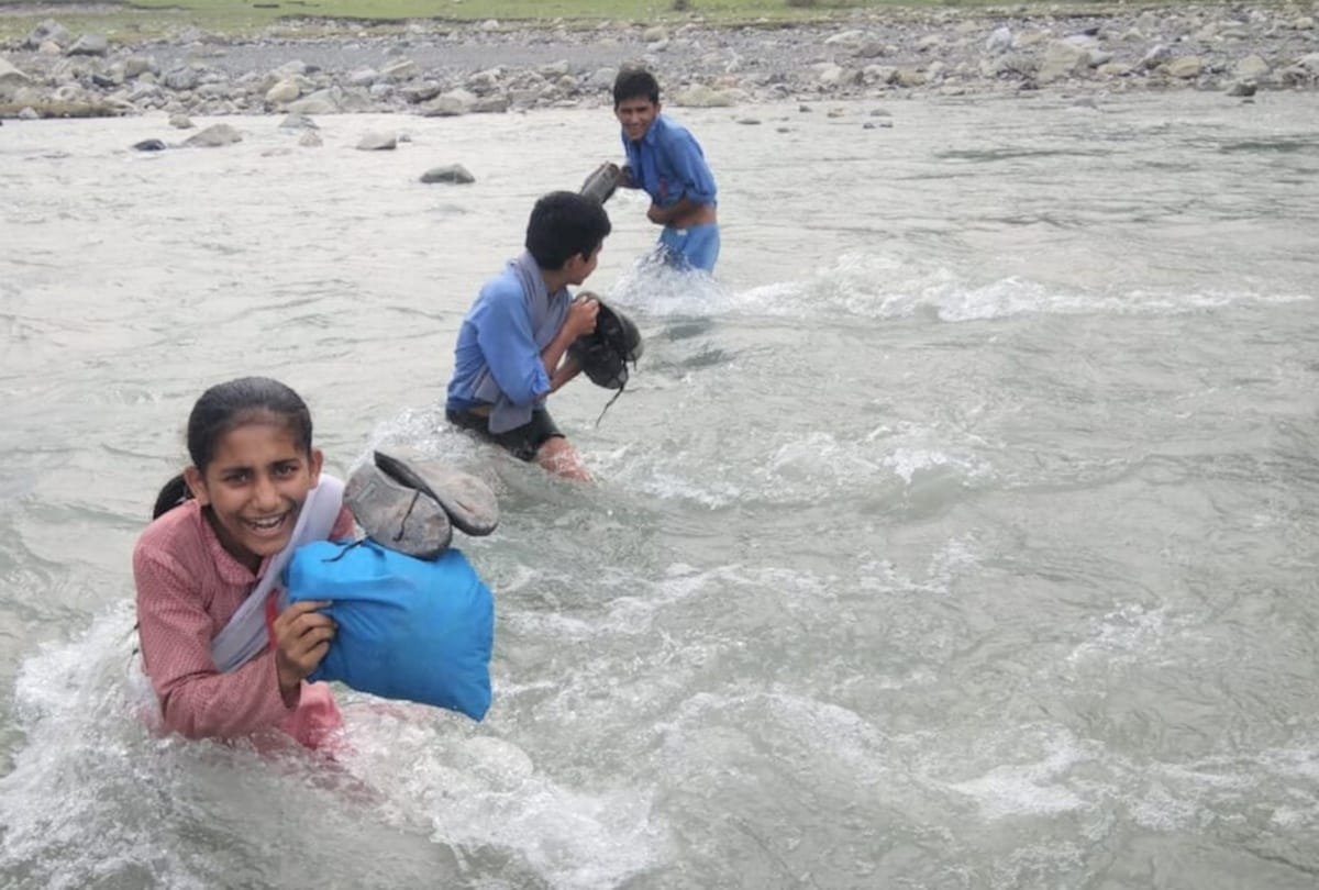 students are reaching school by crossing flooded river on putting lives on stake