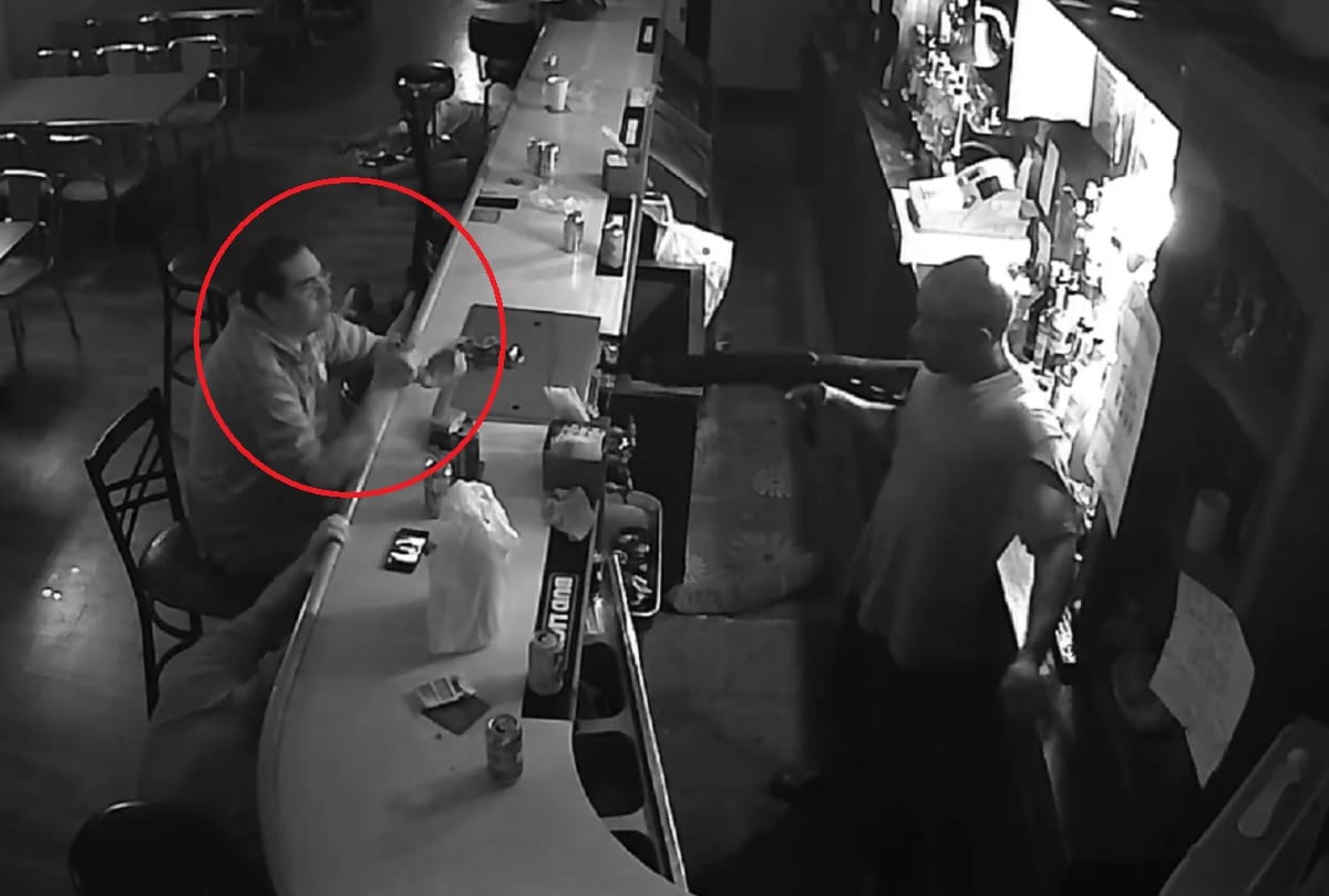 Worlds chillest man sips beer and smoke Cigarette during armed robbery in bar