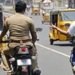 बिना हेलमेट के मोटरसाइकिल चलाता पुलिसकर्मी