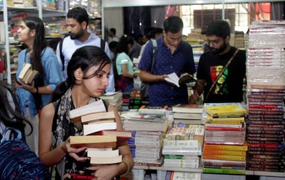 विश्व पुस्तक मेले में किताबें खरीदते युवा