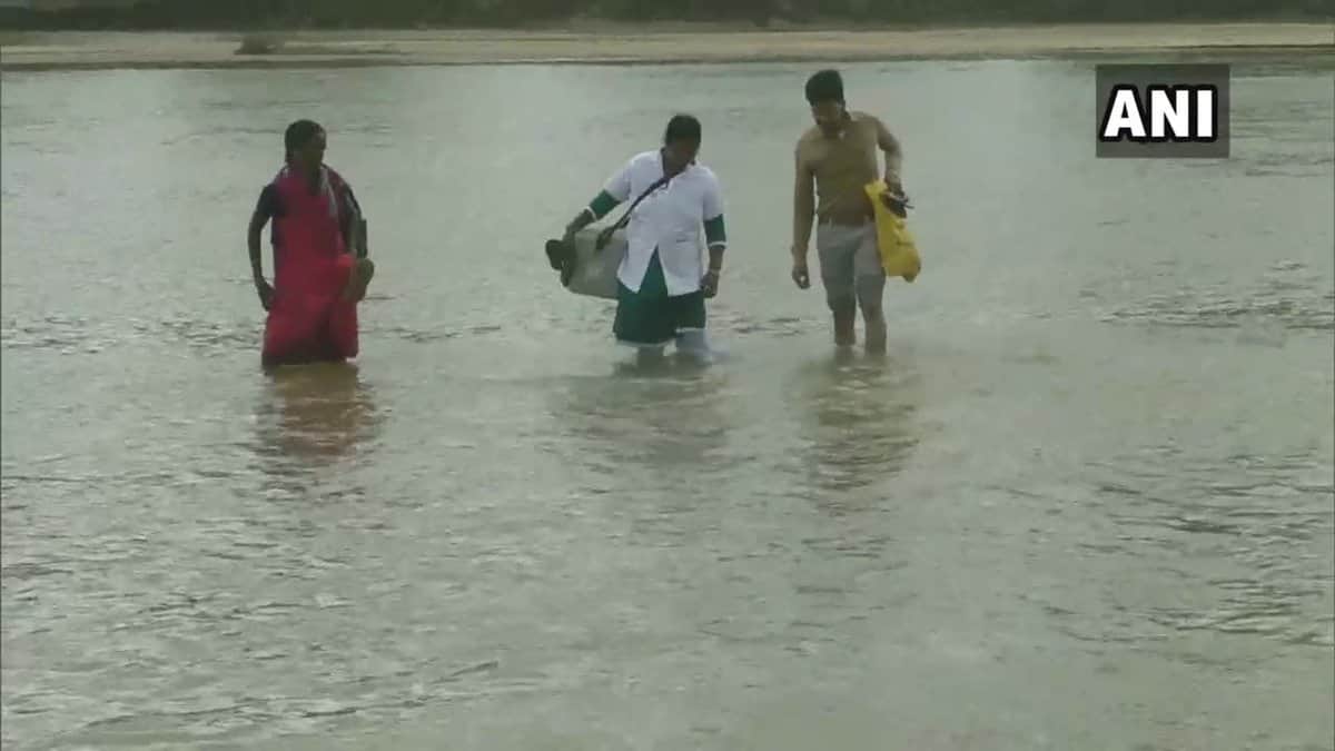 Health worker crosses a river on foot to provide healthcare service to villagers in Chhattisgarh