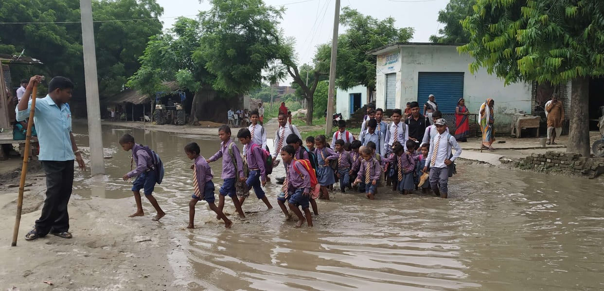 Two feet deep pit on the road, children go to school through dirty water