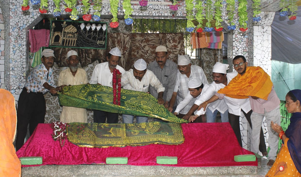 Praying for flood relief by offering a sheet on the tomb