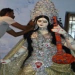 दुर्गा पूजा के लिए मूर्ति को अंतिम रूप देता कारीगर