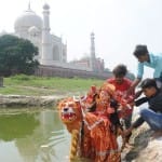 यमुना किनारे बनाए गए कुंडों में प्रतिमा का विसर्जन करते भक्त