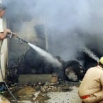 रुई गोदाम में लगी आग को बुझाते पुलिसकर्मी