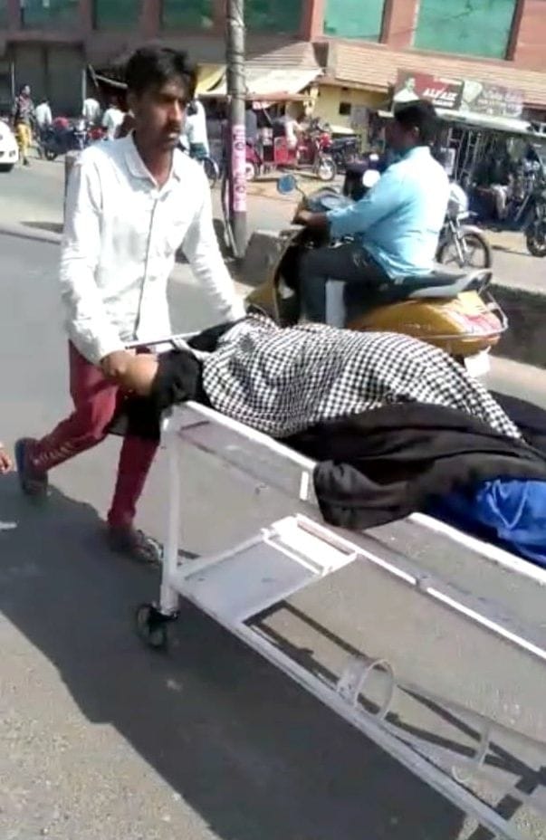 wife did not get treatment in district hospital, husband  run with wife on stretcher