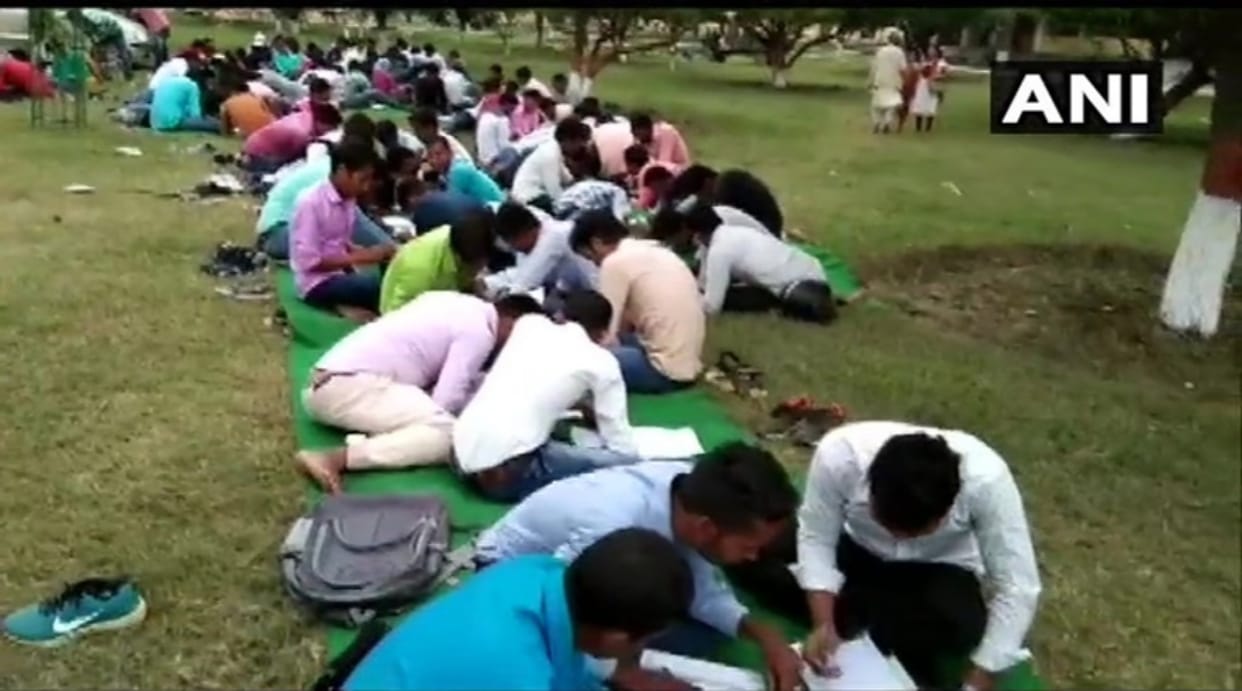 bihar college students gave exam in an open ground and sitting on stairs