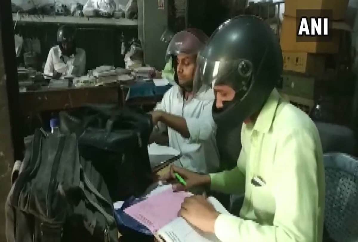 government employees of banda electricity department wear helmets in office to protect themselves