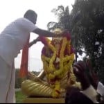 मूर्ति पर माला चढ़ाते सदस्य