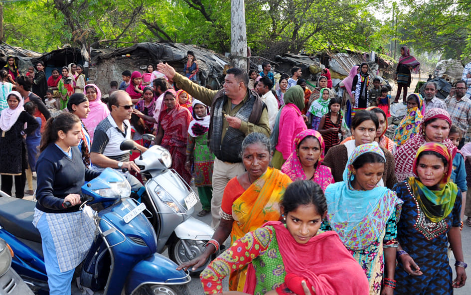 Women in front of JCB went to remove encroachment