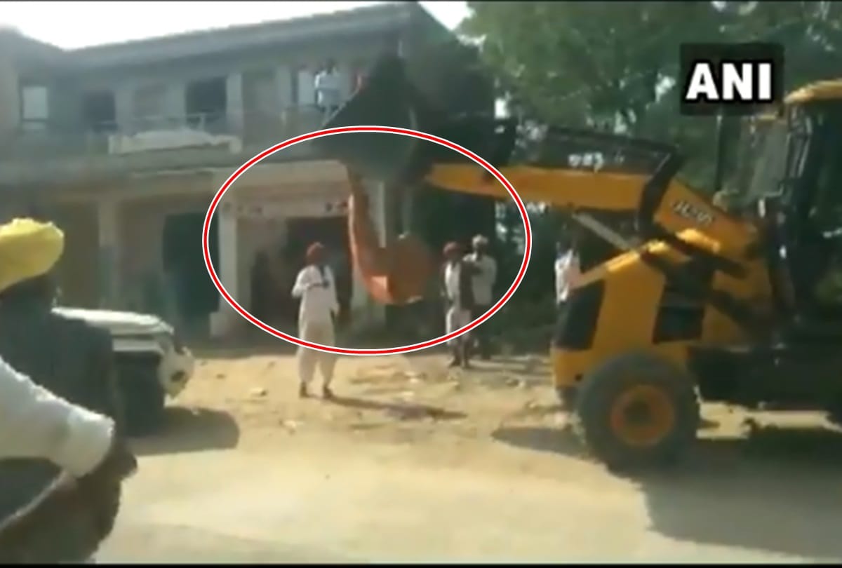 Sarpanch Rekha Devi hanging from JCB to stop anti encroachment campaign in Jalore