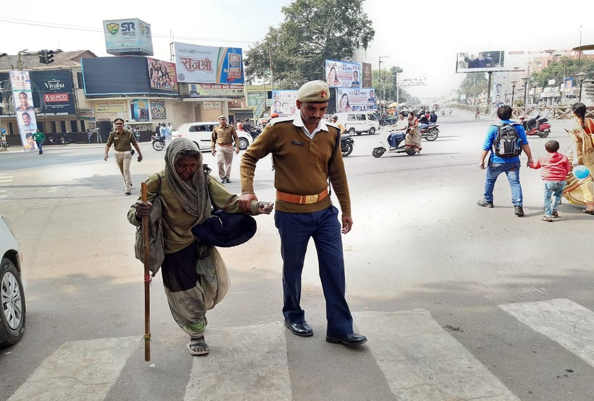 Jhansi traffic policeman helps old woman to cross the road