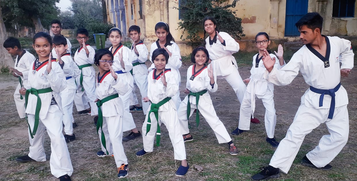 Daughters learning taekwondo and martial arts tricks