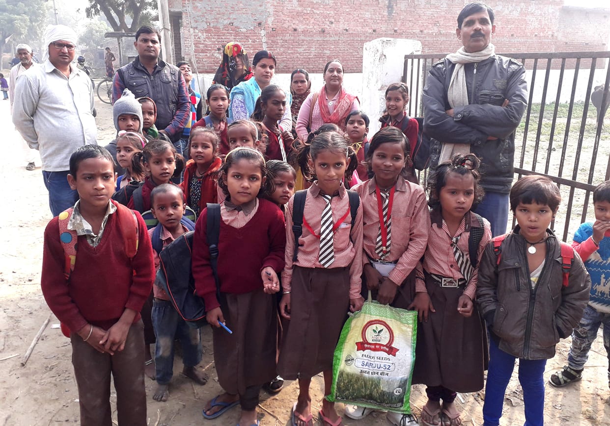 Students and teacher outside, villagers closed cattle in school