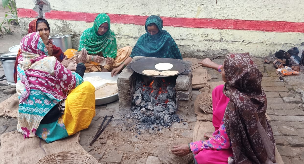 Mid-day meal being cooked on the stove by burning wood and dung