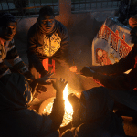 अलाव जलाकर तापते लोग