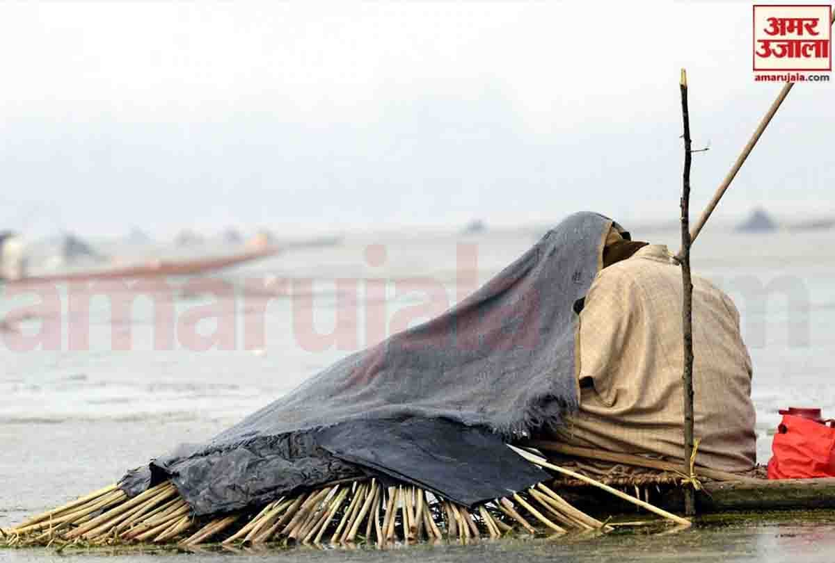 Fishermen cover their heads with blankets to catch fish in Anchar lake in Srinagar