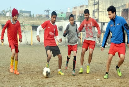 फुटबॉल खेलते नौजवान