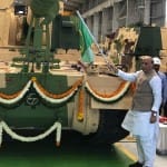 तोप को हरी झंडी दिखाते राजनाथ सिंह