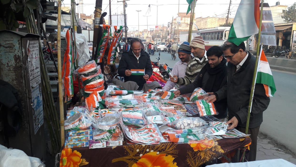 People compete to buy tricolor flag in the market