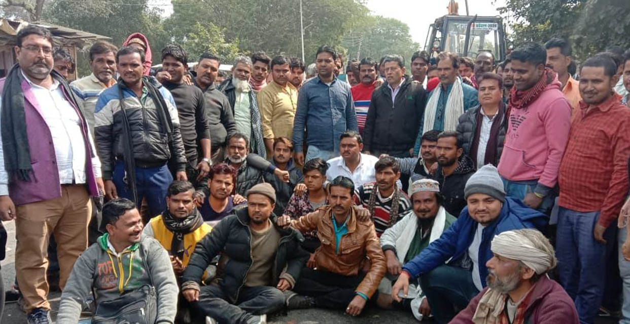 Vegetable vendors being razed sit in front of JCB
