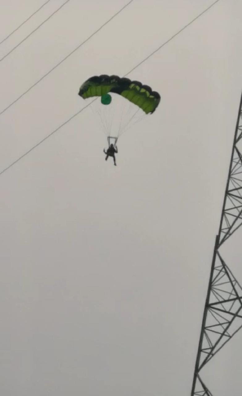 Foreign tourists jump from electric Tower with parachute