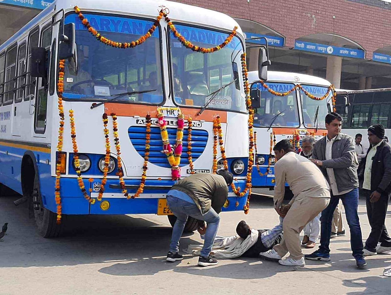 employees lay in front of the wheel of a bus that ran under the kilometer scheme
