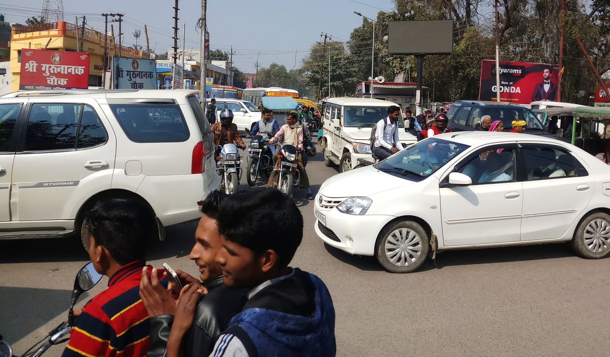 Vehicles parked on the road, people struggling with jams