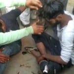 युवक के सिर के बाल काटते लोग
