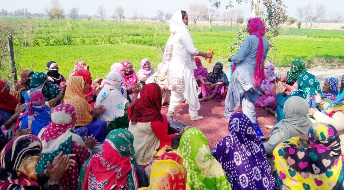 women atanding a sit in protest against the water in the railway undepass