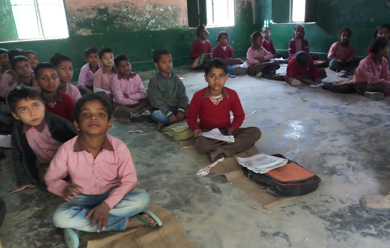 Sitting on a sackcloth studying school in English medium