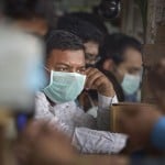 सफदरजंग अस्पताल के बाहर एक दवा की दुकान पर मास्क पहने लोग
