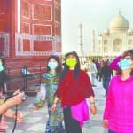 ताजमहल पर मास्क लगाकर संक्रमण से बचाव की कवायद करते विदेशी सैलानी