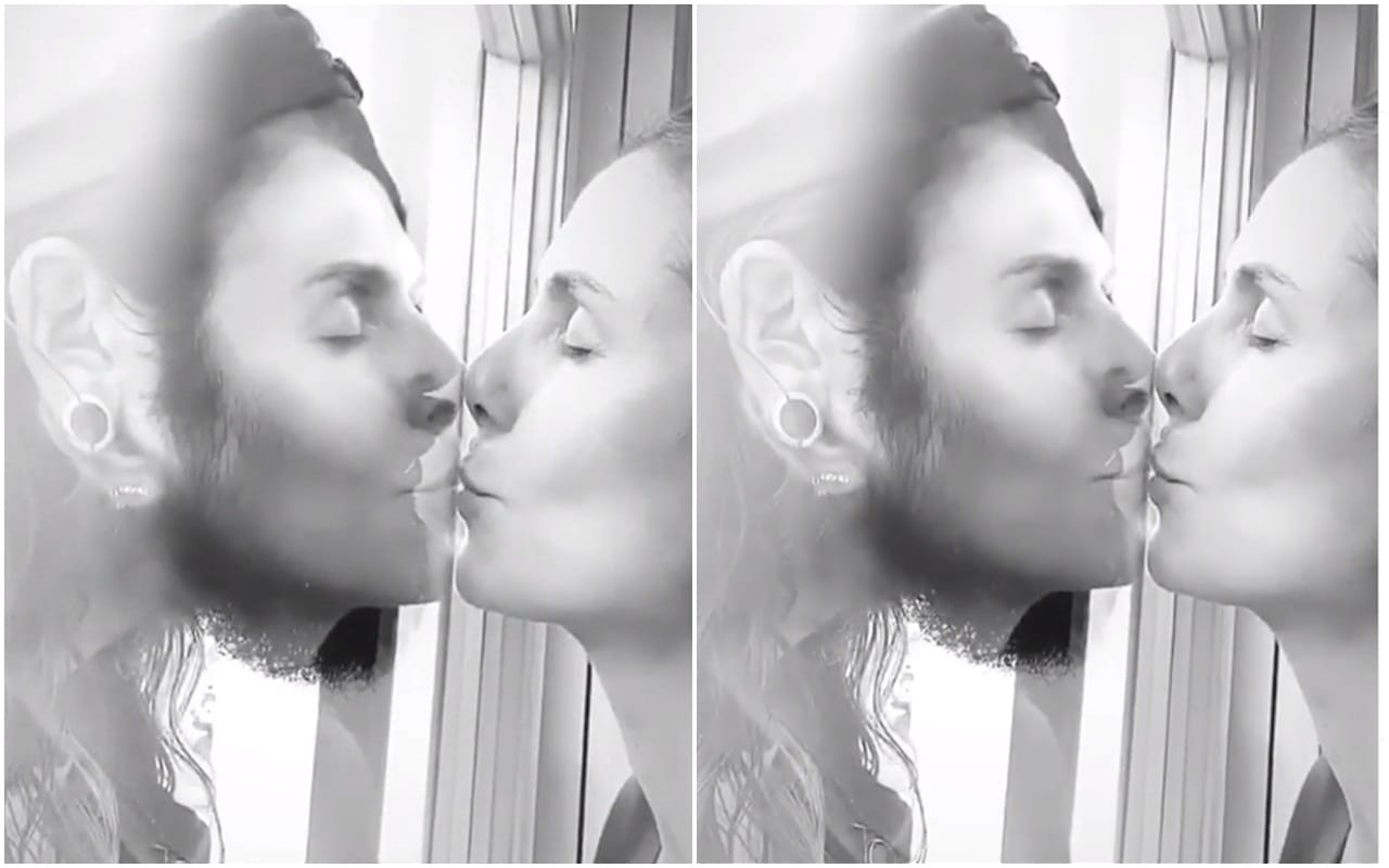 Heidi Klum kissing husband Tom Kaulitz through a glass window await coronavirus test results