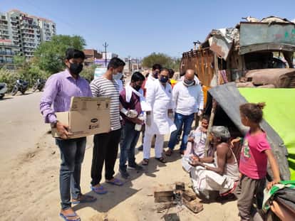 गरीबों को भोजन पैकेट देते कांग्रेसी