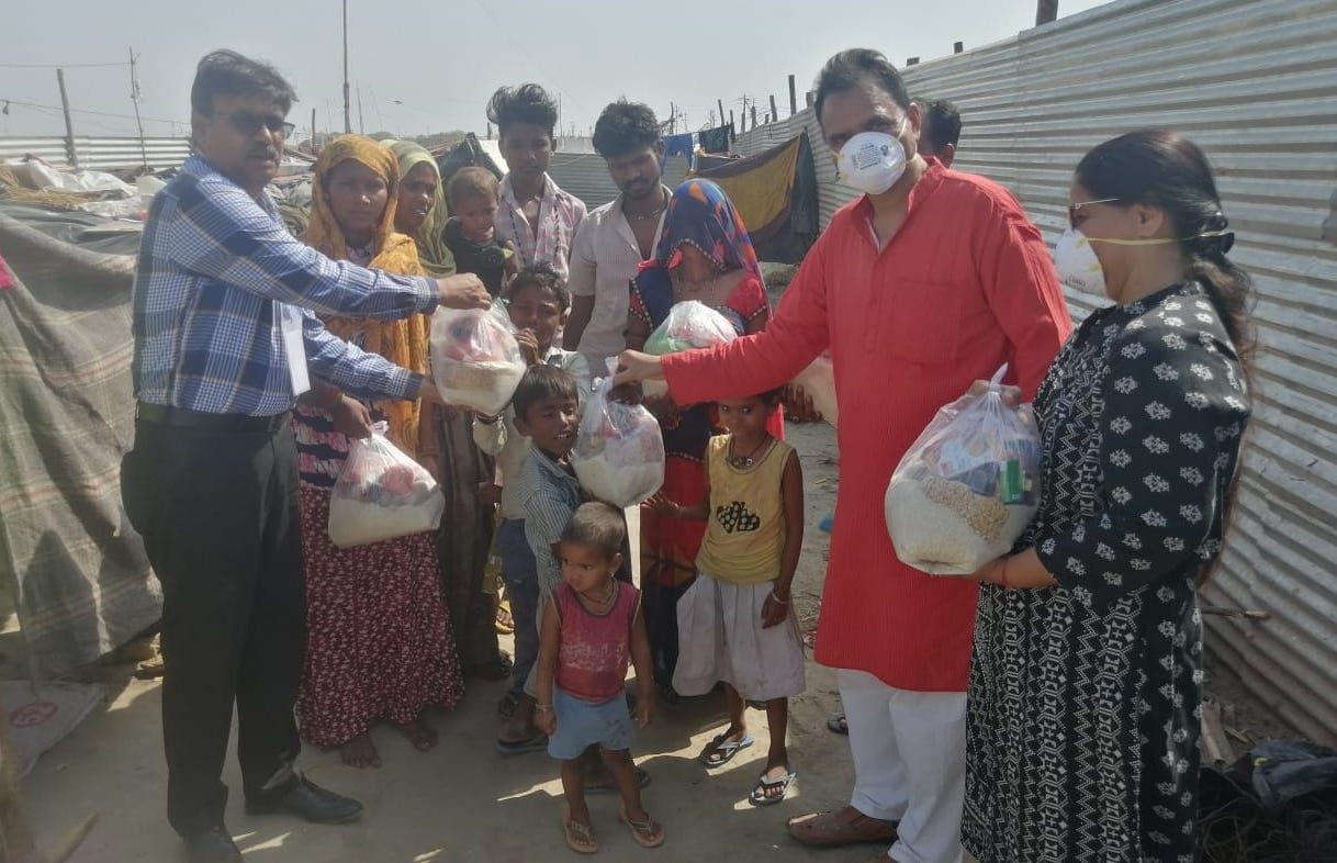hands extended to help ditributed food packets food grains
