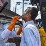 रांची में एक शख्स की कोरोना जांच करता स्वास्थ्य कर्मी।