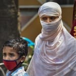 कोलकाता में लॉकडाउन के दौरान एक अस्पताल में खाने के पैकेट बांटे जाने का इंतजार करती युवती।
