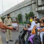 लॉकडाउन के दौरान घर से बाहर निकले एक परिवार को समझाता पुलिस कर्मी।