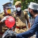 लॉकडाउन के बावजूद घर से बाहर निकले एक शख्स का कोरोना वायरस से खतरे के बारे में समझाता पुलिसकर्मी।