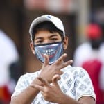 कोरोना वायरस से बचाव के लिए मास्क पहने हुए बच्चा।