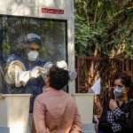 मुंबई में कोरोना की जांच के लिए नमूना एकत्र करते हुए एक स्वास्थ्य कर्मी।