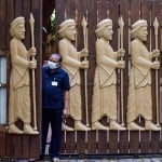 मुंबई के माटुंगा में चिकित्सा शिविर चला रहे बीएमसी के स्वास्थ्य कर्मियों की ओर देखता शख्स।