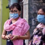 नई दिल्ली में लॉकडाउन के दौरान खाने के पैकेट लेने के लिए इंतजार करती महिलाएं।